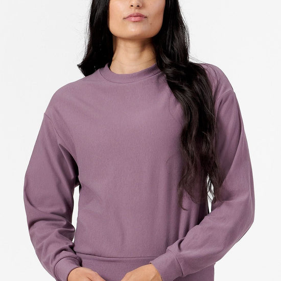 Woman wearing a purple sweatshirt and black leggings