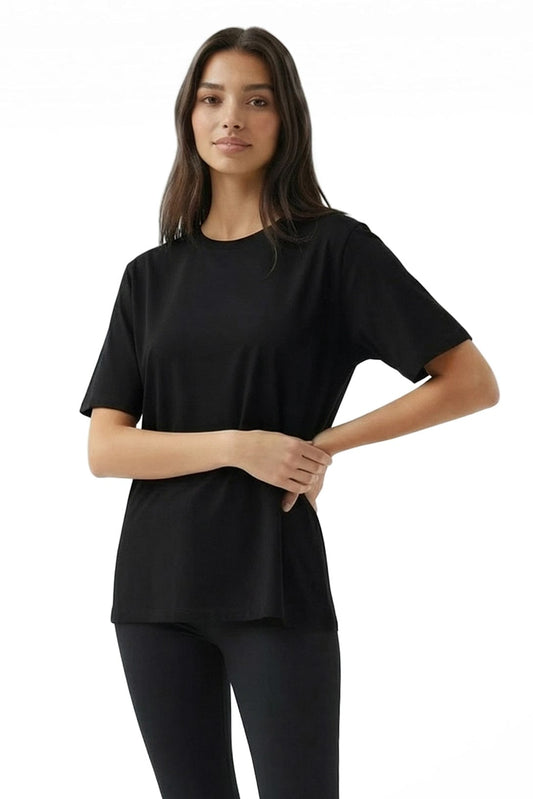 Woman wearing a black t-shirt and leggings on a white background