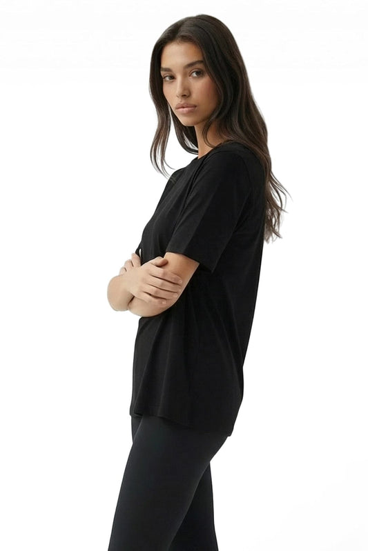 Woman wearing a black top and pants on a white background