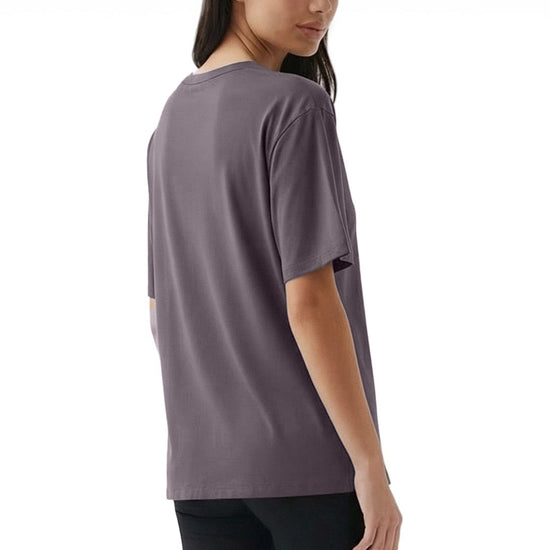 Woman wearing a gray t-shirt and black leggings on a white background