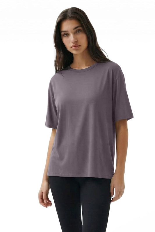 Woman wearing a purple t-shirt and black pants on a white background