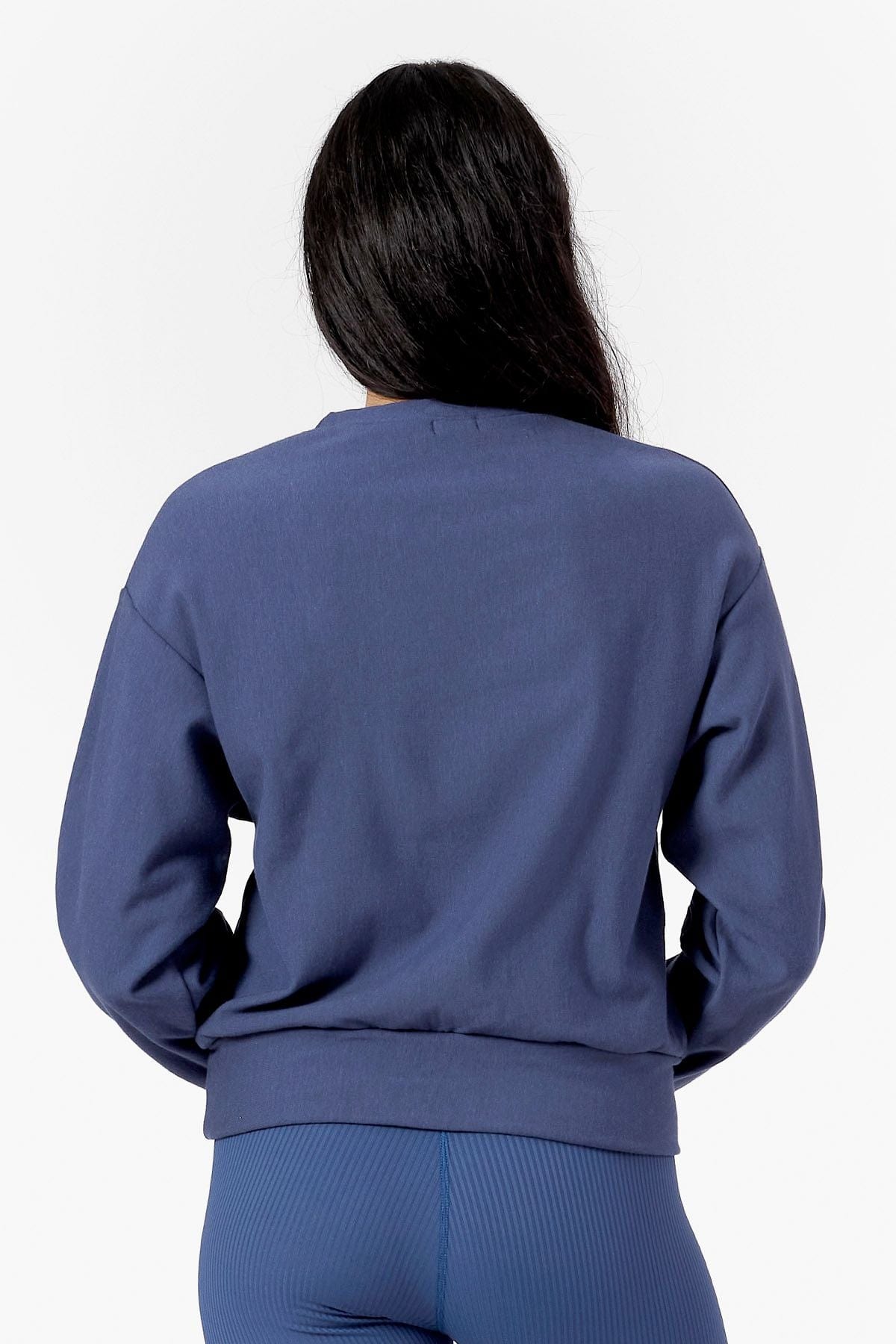Back of a woman wearing matching crew neck and leggings in blue