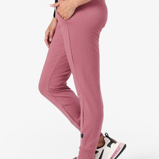 Side of a woman wearing cozy pink fleece joggers
