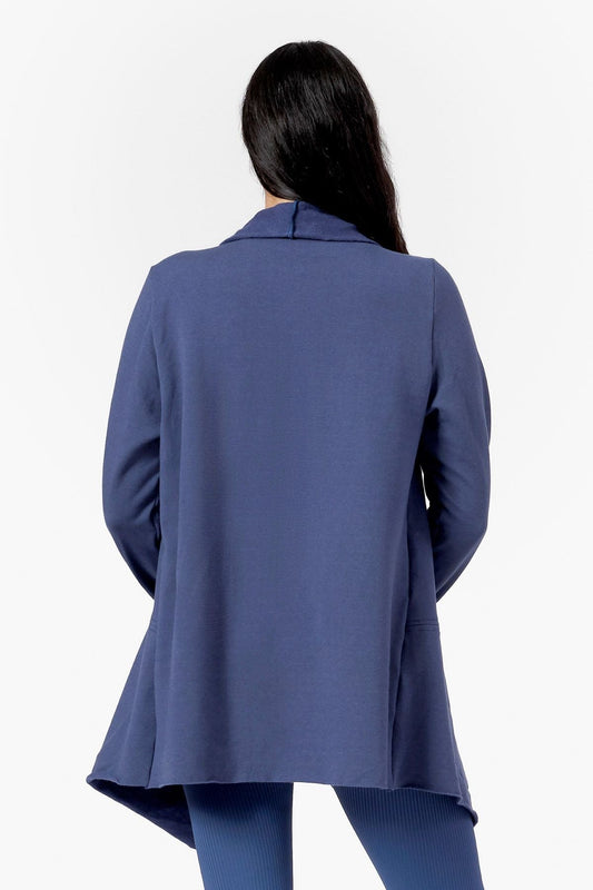 Back of a woman wearing a blue drapey fleece jacket 
