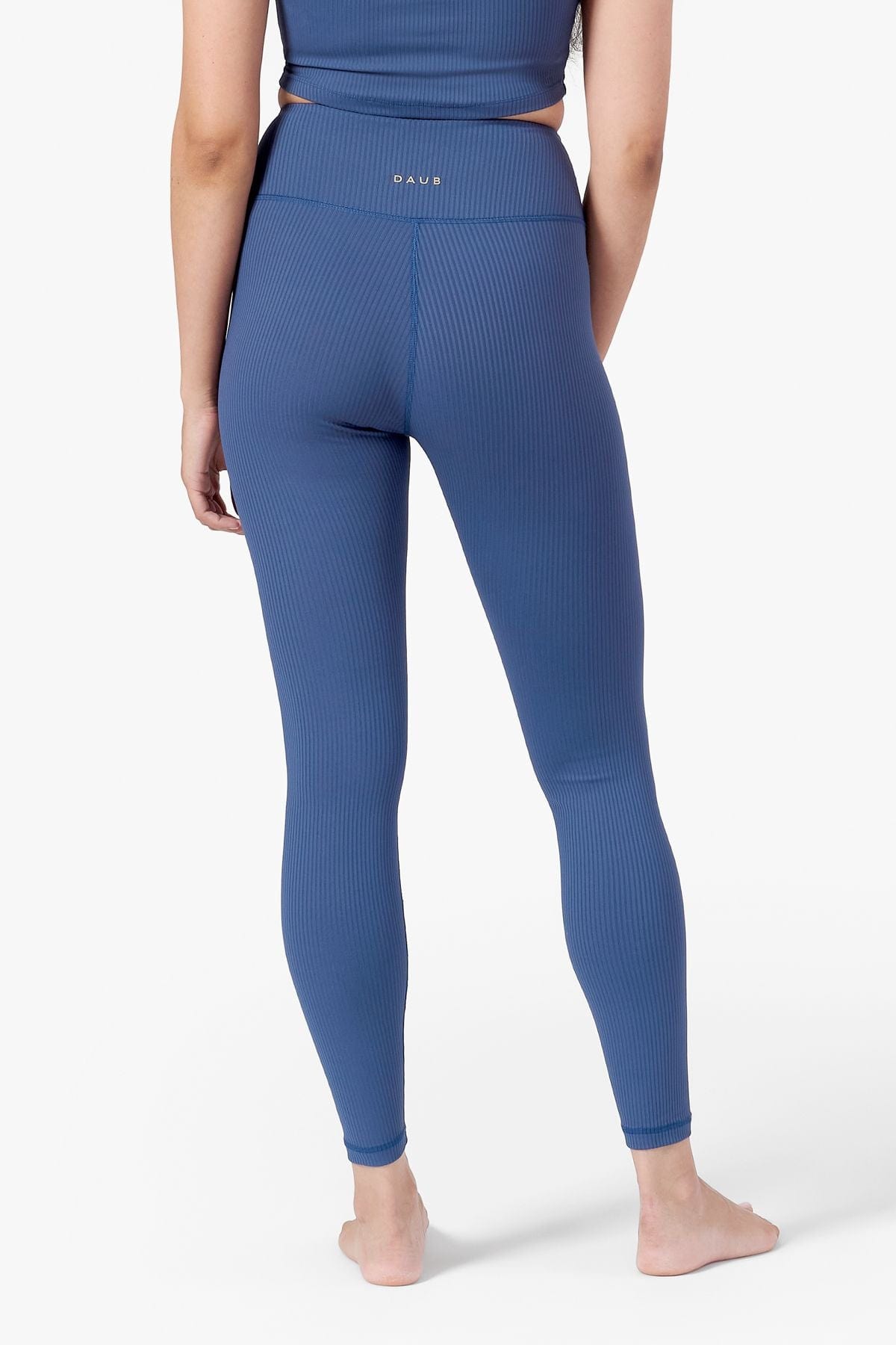 Back of a woman wearing blue ribbed leggings