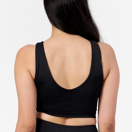 back of a woman wearing a low back reversible matte black bra