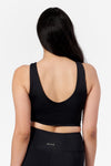 back of a woman wearing a low back reversible matte black bra