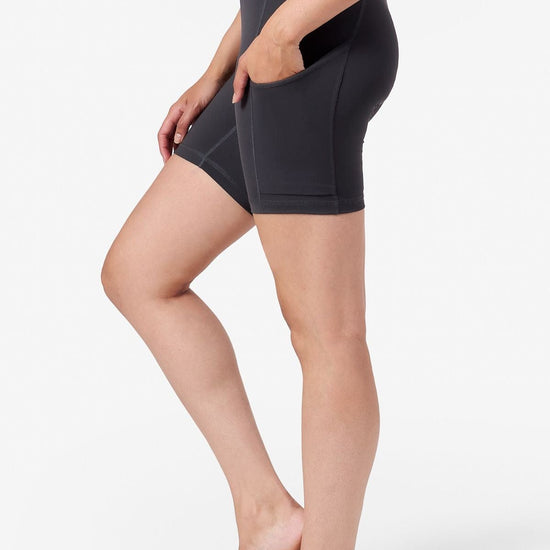 a woman's side profile wearing bike shorts with her hands in her side pockets