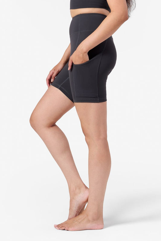 a woman's side profile wearing bike shorts with her hands in her side pockets