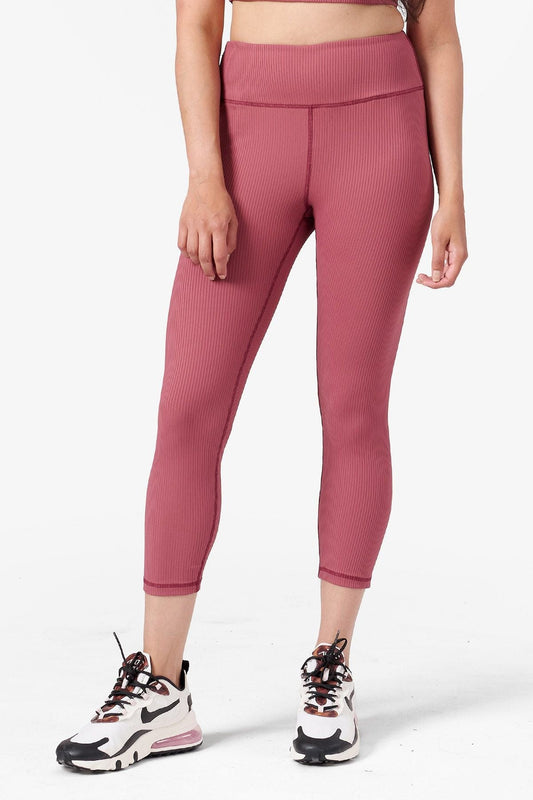 half view of a woman wearing mid length pink ribbed leggings