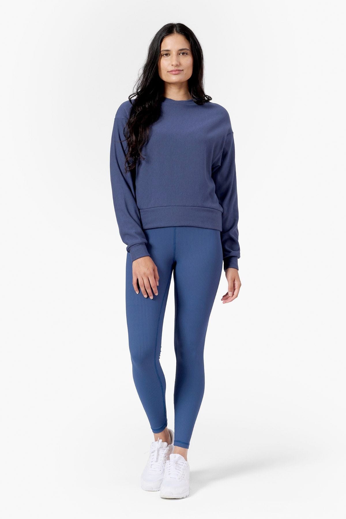 a woman wearing ribbed blue leggings and blue sweater