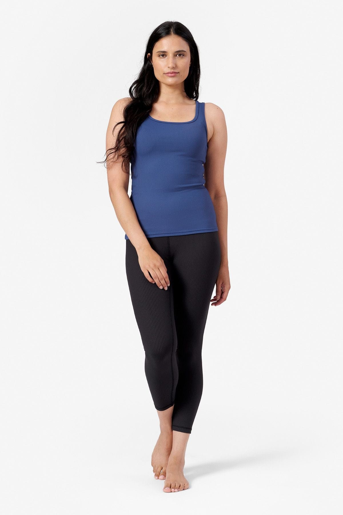 a woman wearing black ribbed leggings with a blue ribbed tank top