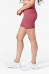 Side view of a woman wearing cycling shorts in pink