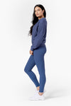 Side of a woman wearing a matching crew neck and pants in blue