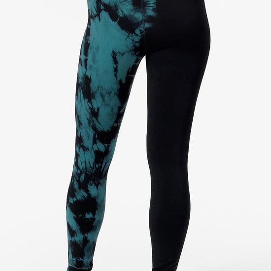 back view of a woman's legs wearing leggings which are tie dye teal and black