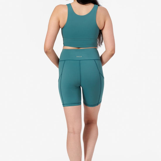 back view of bike shorts in teal with matching teal crop top