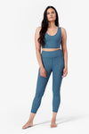 full view of woman wishing a matching ribbed sports set with crop top and leggings