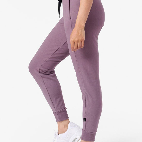 Side of a woman wearing purple joggers