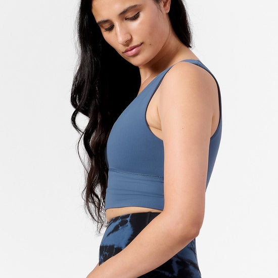 side view of a woman wearing a blue sports crop top