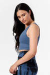 side view of a woman wearing a blue sports crop top