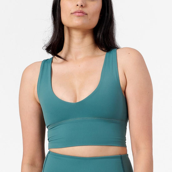 a woman wearing a teal sports bra with matching teal shorts