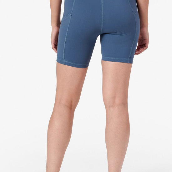 a woman wearing bike shorts with pockets on the side in blue