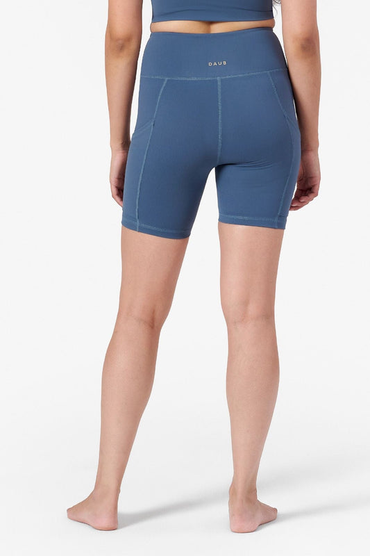 a woman wearing bike shorts with pockets on the side in blue