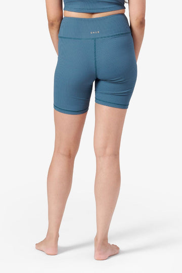 back view of a woman wearing teal ribbed bike shorts 