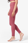 side view of a woman wearing pink ribbed leggings which are ankle length 