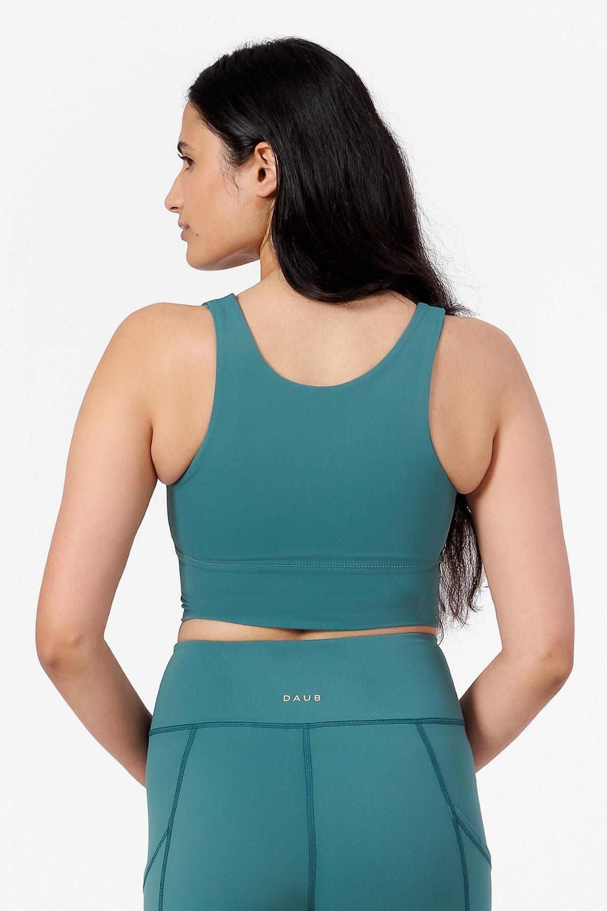 a woman wearing a teal high neck crop top with matching teal shorts