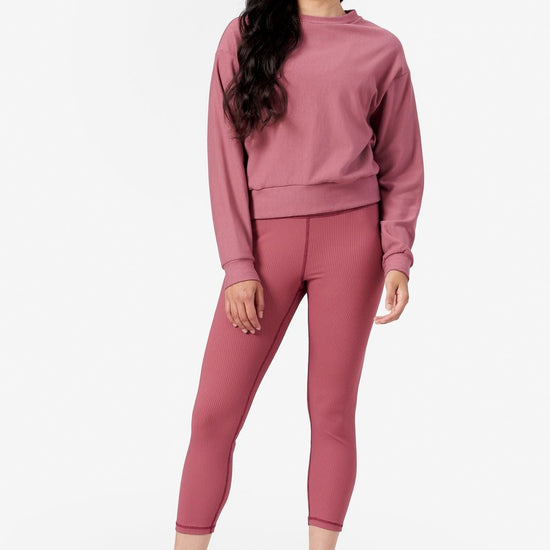 a woman wearing pink ribbed legging with a pink fleece crew neck sweater