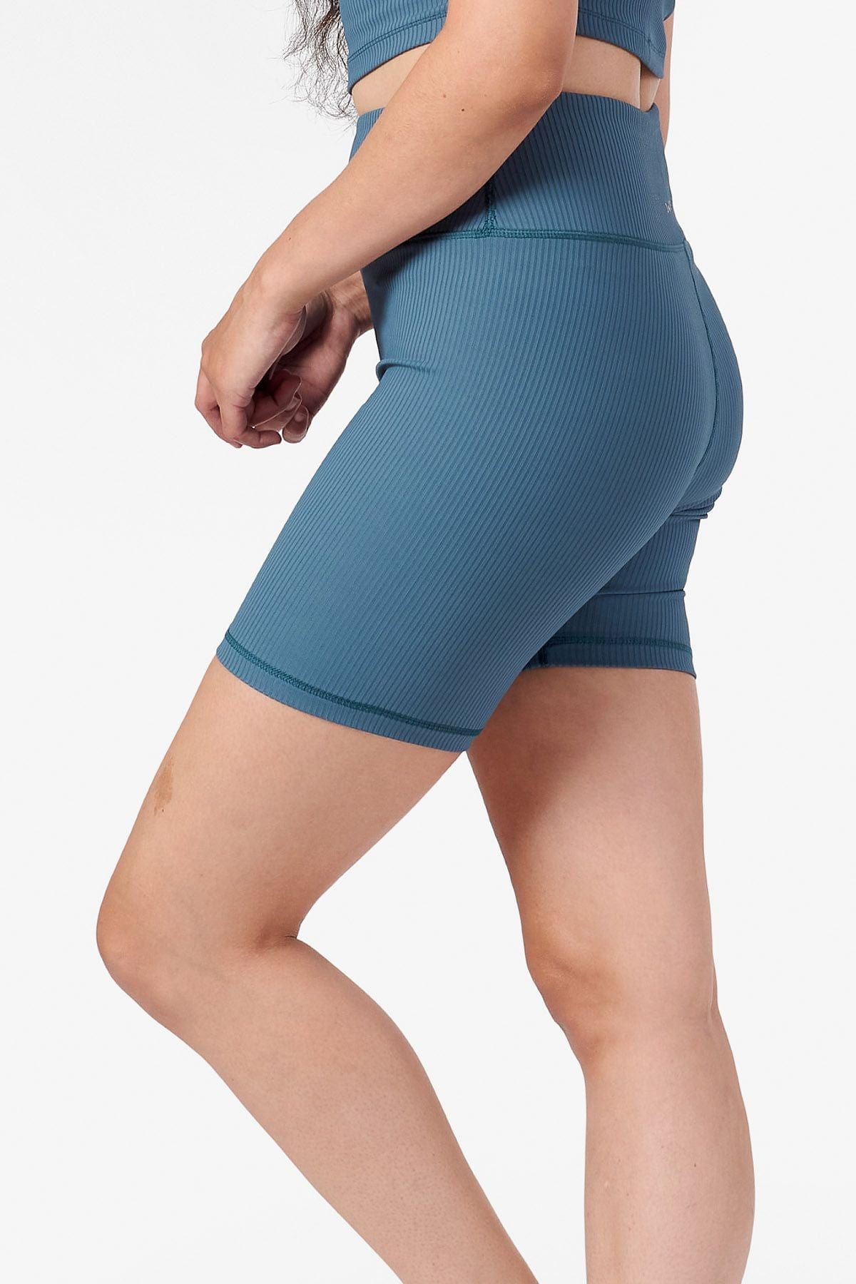 side view of a woman's legs wearing bike shorts in teal 