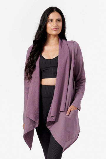 a woman wearing a loose fitted purple jacket with her hand in the pocket