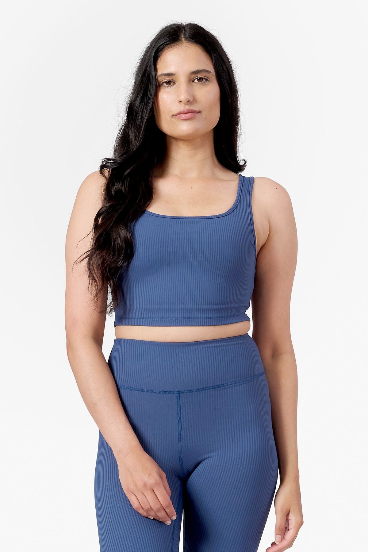 front of a woman wearing square side of a reversible ribbed sports bra in blue