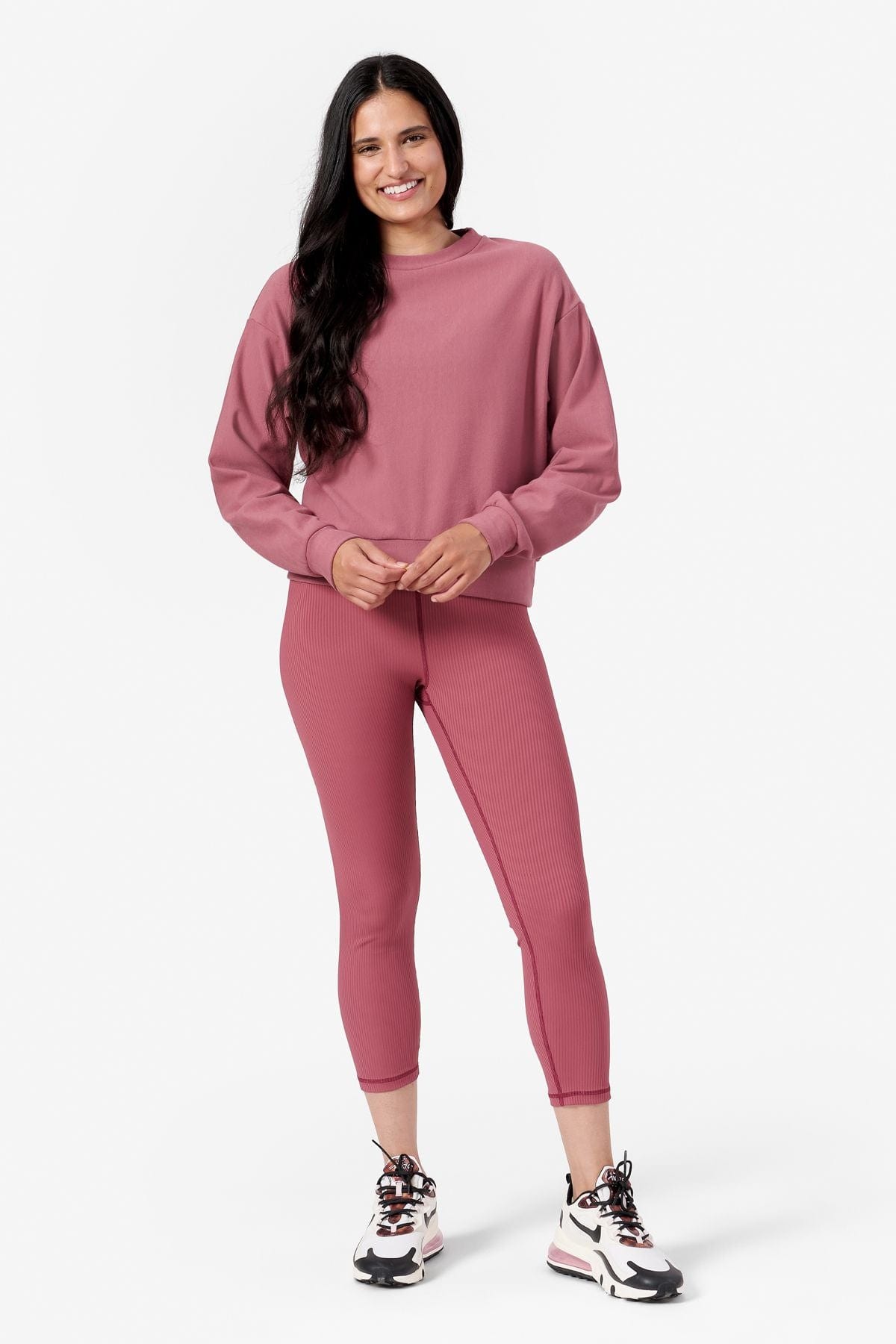 Woman wearing pink crew neck sweatshirt and pink leggings