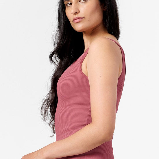 side view of a woman wearing a pink ribbed tank top 