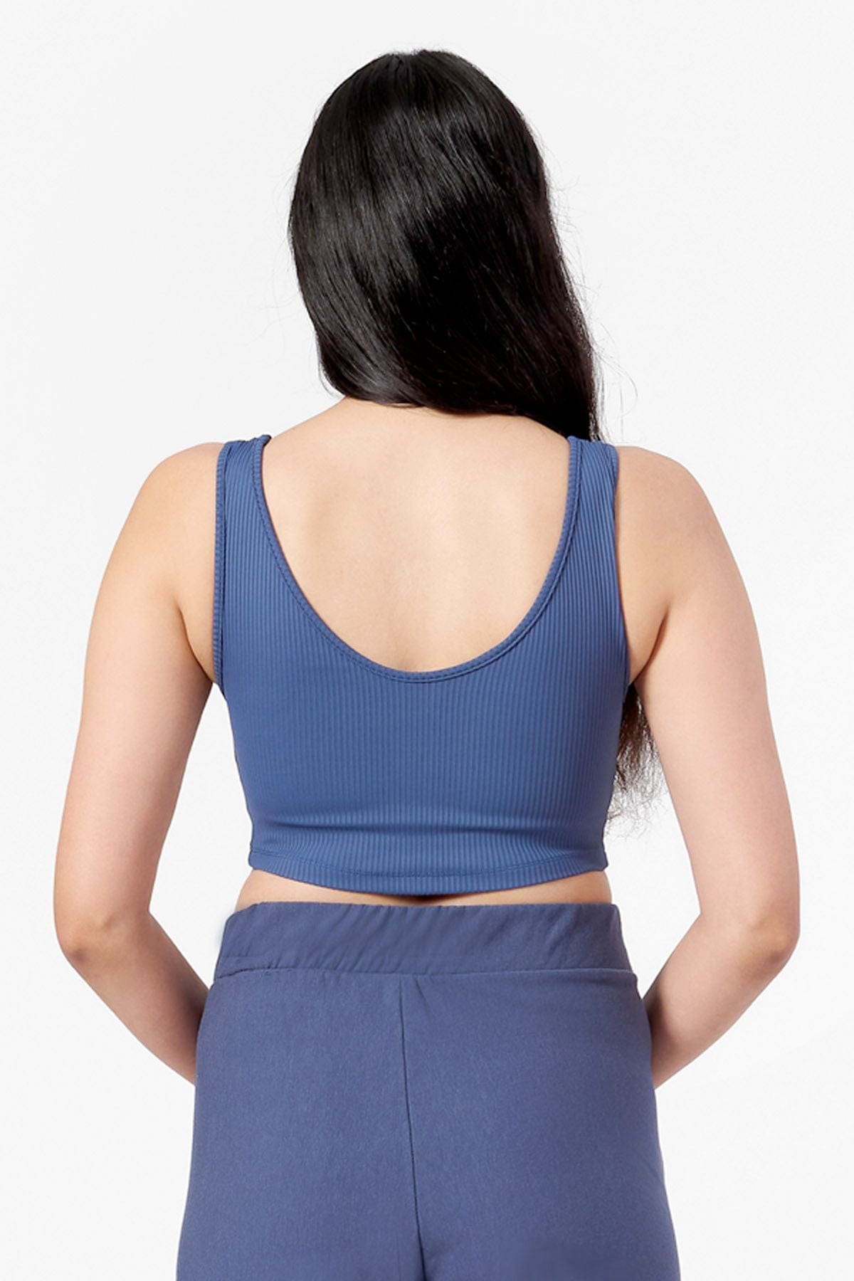 the back view of a woman wearing a blue crop top with a low scoop neck line