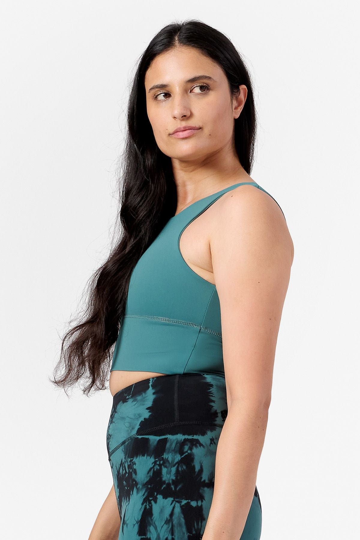 side view of a woman wearing a teal sports bra