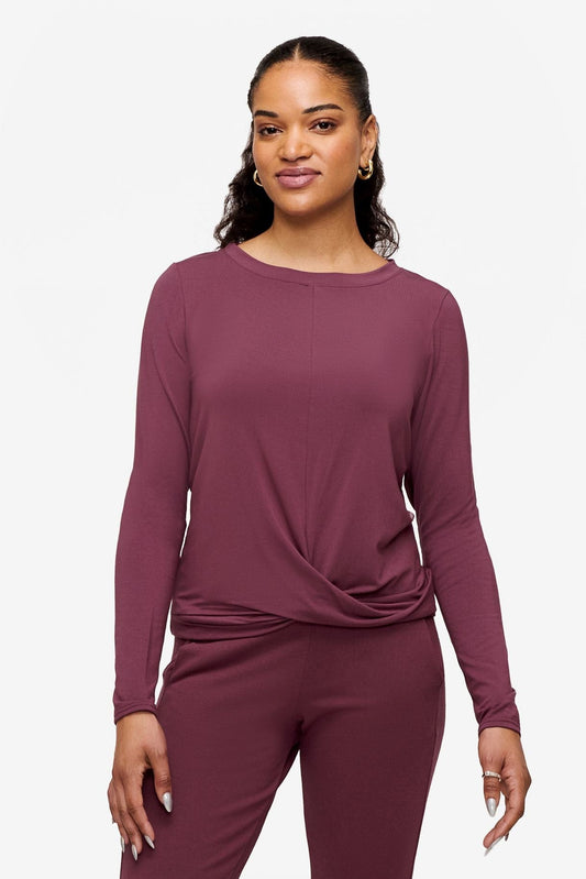 woman wearing a deep pink long sleeve top with twist in the front 