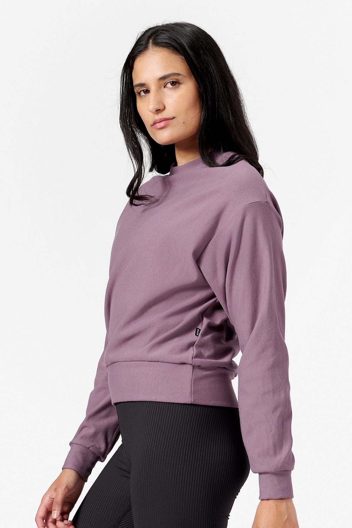 Side of a woman wearing a purple Sweatshirt