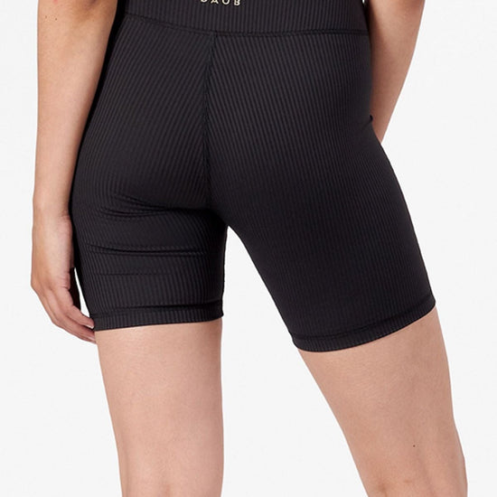 The back of a woman modeling black bike shorts.