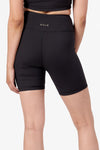 The back of a woman modeling black bike shorts.