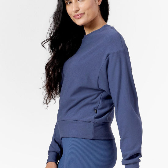 Woman smiling wearing a blue sweatshirt 
