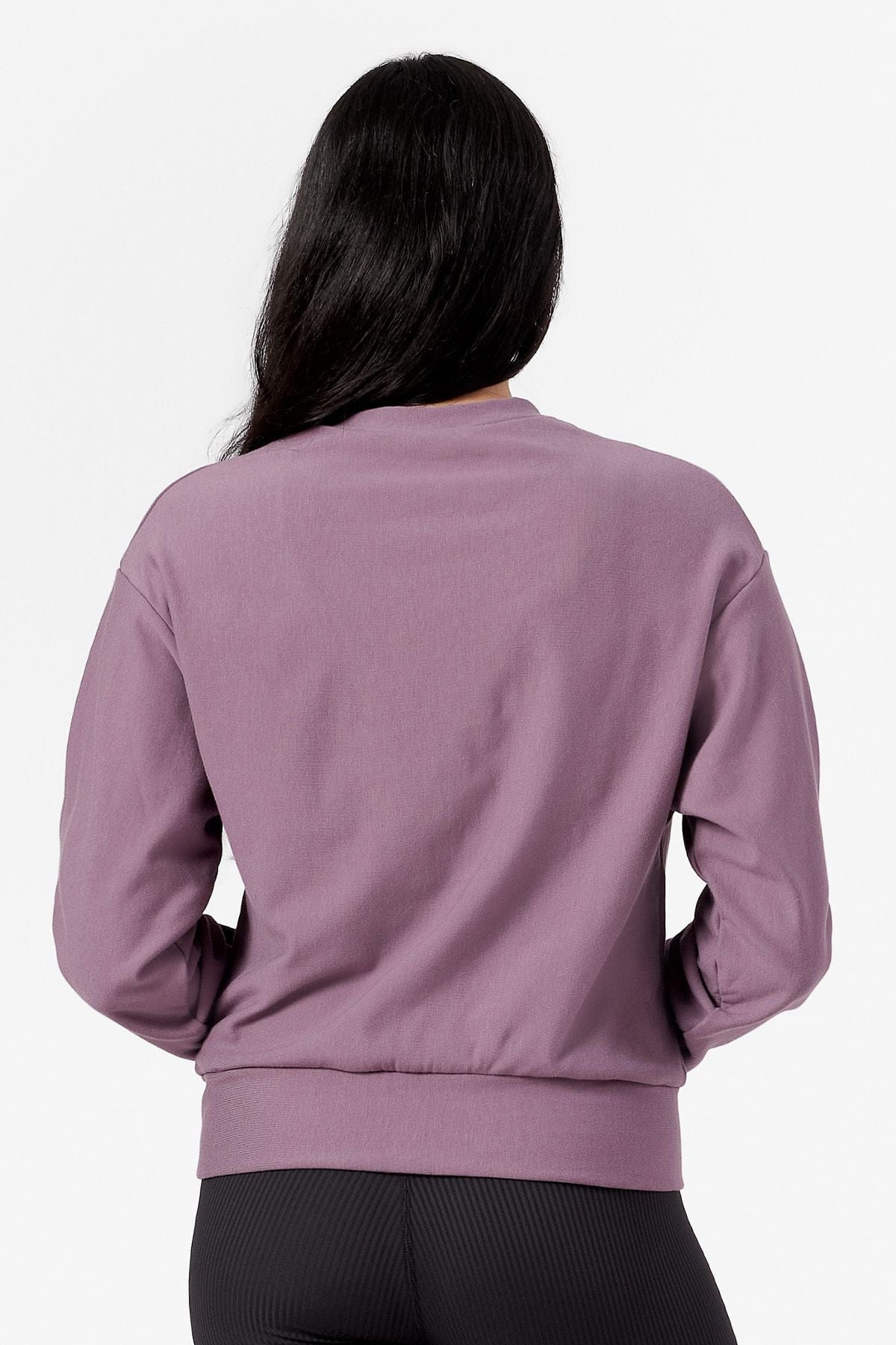 Back of a woman wearing a purple crew neck sweatshirt