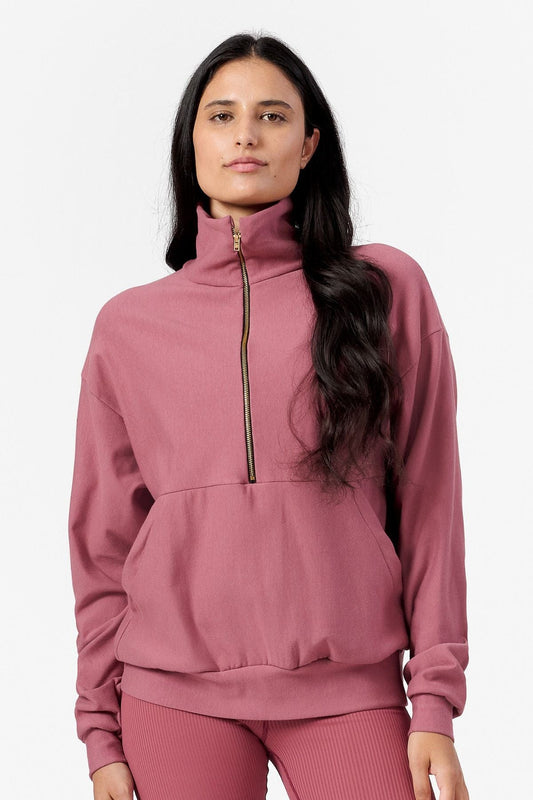 Woman wearing a pink half zip sweatshirt