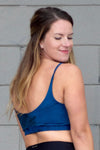 Back of a woman wearing blue and black tie dye swim top