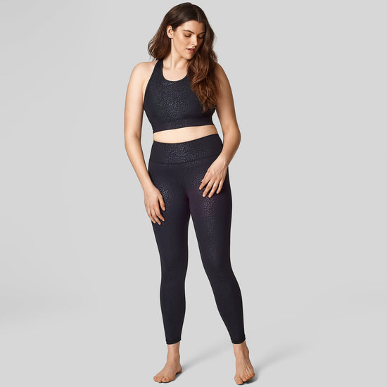 A size 12 model wears a size L in the black cheetah print long-line sports bra and high waisted legging.