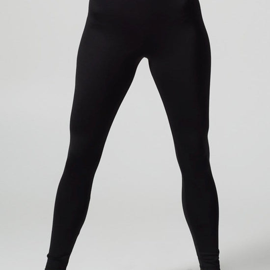 A woman’s legs are shown wearing black leggings.