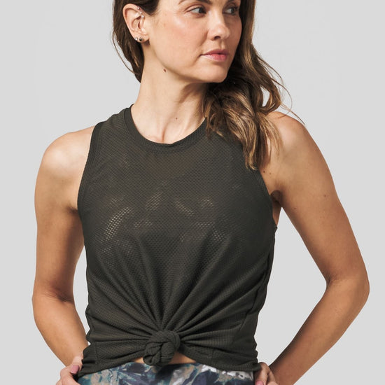 Brown hair women wearing an olive green tank top tied at the waist.