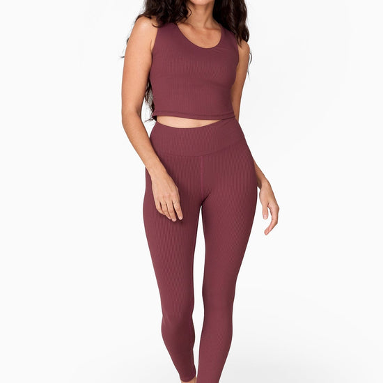 a tall slender woman with waist length hair wears a brownish tank top with matching ribbed leggings 